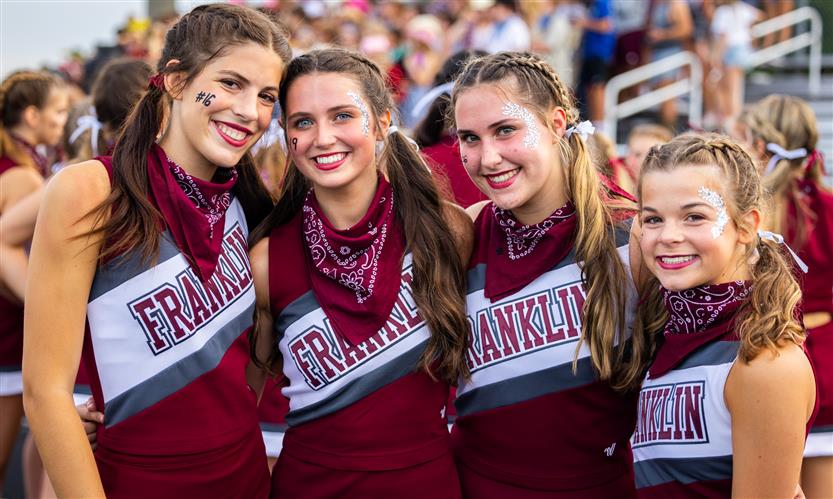 Four cheerleaders smile